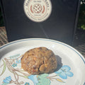 Almond Joy cookie on a floral plate in front of a Mannazello Treatz bakery box