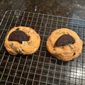 Two Brown Butter Cookies & Cream cookies on a wire cooling rack, each topped with a half chocolate sandwich cookie